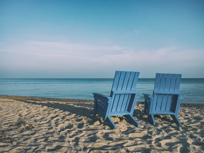 两个蓝色的水域附近的沙滩椅

